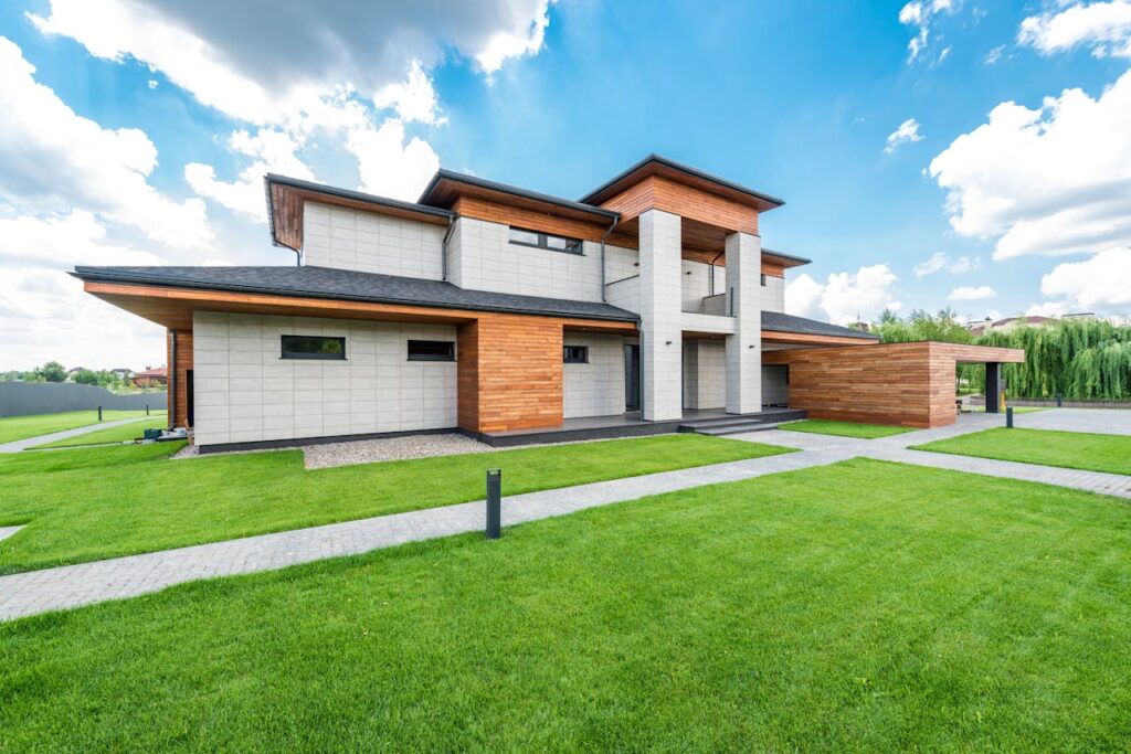 Exterior of residential house with green trees and lawn growing in countryside in summertime